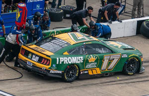 NASCAR維修站人員維修綠色和黃色的17號賽車。