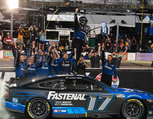 NASCAR車手和團隊在夜間賽車上慶祝勝利。