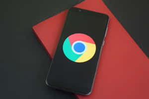 智能手機在紅色筆記本上顯示Chrome標誌