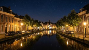 夜晚寧靜的運河，星空和溫暖的路燈倒映在水中，旁邊是歷史建築。