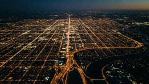 夜晚城市網格的空中景觀，發光的街道和高速公路蜿蜒穿過黑暗的土地。