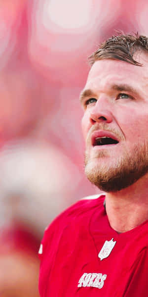 身穿紅色49ers球衣的NFL球員專注地向上看。