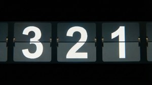一個機械翻頁時鐘，在黑色背景上以白色顯示倒數數字 3 2 1。