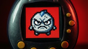 憤怒嘅像素化生物喺紅色背景嘅 Tamagotchi 屏幕上。