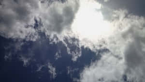 陽光穿透白雲，映照在深藍色的天空上