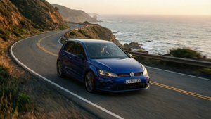 藍色Volkswagen Golf R在日落時分行駛在海岸公路上，享有海景