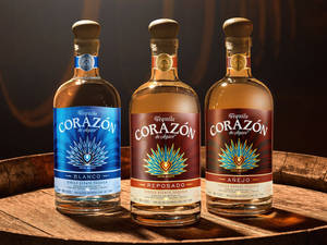 三瓶Corazón de Agave龍舌蘭酒展示在木桶上。