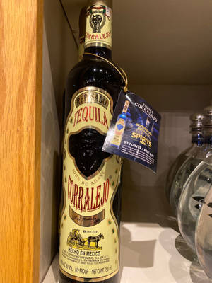 一個Corralejo Reposado龍舌蘭酒瓶放在架子上，帶有藍色獎勵標籤。