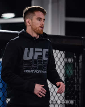 夜晚八角籠內穿著黑色連帽衫的男性UFC拳手。