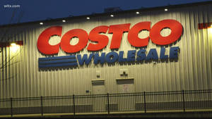 Costco Wholesale商店夜間外觀，帶有發光標誌和金屬圍欄。