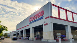 日落時分，Costco Wholesale商店外觀，有汽車和人群。