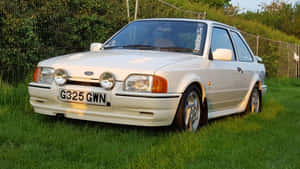 奶油色福特 Sierra Cosworth 在日落時停泊在草地上。 — 5120x2880 壁紙