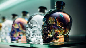 虹彩骷髏酒瓶在玻璃架上展示，帶有色彩繽紛的反射。