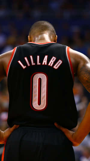 籃球運動員 Damian Lillard 身穿黑色零號球衣，雙手叉腰站在球場上。