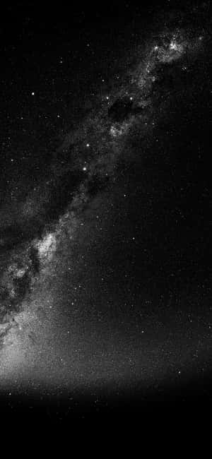 銀河系在繁星點點的夜空中以黑白色彩閃耀。