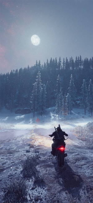 摩托車手在夜晚的滿月下獨自穿過雪地森林。
