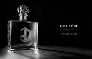 Deleón Tequila 瓶子，銀色瓶蓋，深色表面，帶有品牌文字。