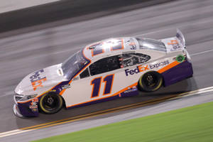FedEx Express NASCAR 賽車在夜間賽道上高速行駛