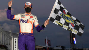NASCAR車手在黃昏比賽勝利後手持格仔旗