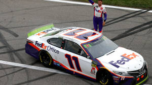 NASCAR車手在賽道上於他的FedEx Office賽車上慶祝勝利。