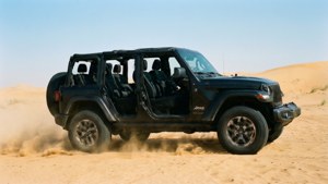 黑色Jeep Wrangler無門車在沙漠沙丘上行駛