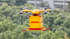 黃色DHL無人機在綠樹和城市建築上方運送包裹。