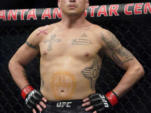 一位紋身的男性UFC拳手站在八角籠中，雙手叉腰。 — 紋身 壁紙
