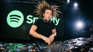DJ在混音台前打碟，螢幕顯示Spotify標誌，舞台燈光閃爍。