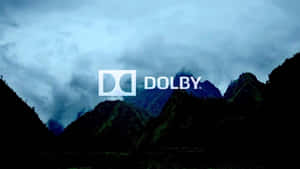 Dolby 標誌顯示在多雲天空下的山景之上。 — 日落大道 壁紙