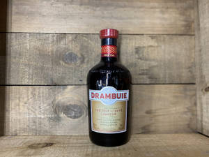 Drambuie 利口酒瓶在木質表面上，背景為木牆