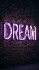 夜間安裝在磚牆上，帶有dream字樣的紫色霓虹燈牌