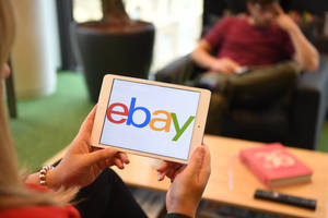 在客廳中手持顯示eBay標誌的平板電腦的人。 — 火影忍者海報 壁紙