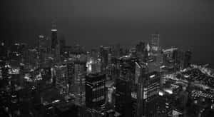 密集城市的夜晚航拍圖，高樓大廈和街道閃爍。 — 黑色 壁紙