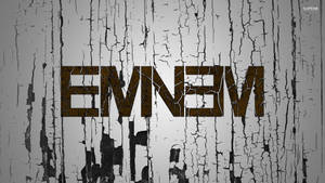 在風化的灰色和黑色木背景上，裂開的棕色字母 'EMNEVM'。