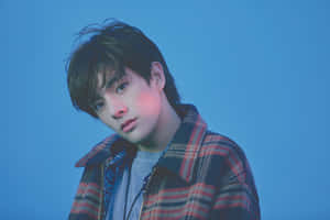 年輕男子穿著格子外套，藍色背景