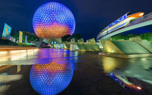 Epcot的測地線球體和單軌列車在夜間亮燈，倒映在濕地上。 — 夜晚 GIF 壁紙