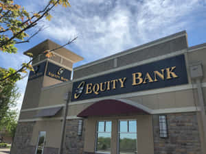 Equity Bank 大樓，金色招牌及石造外牆，藍天白雲下。 — 日落大道 壁紙