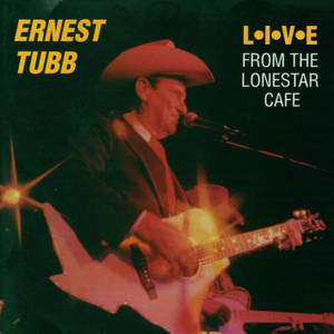 Ernest Tubb 在溫暖的舞台燈光下彈奏結他。