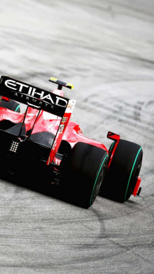 紅黑相間的F1賽車在灰色賽道上疾馳。