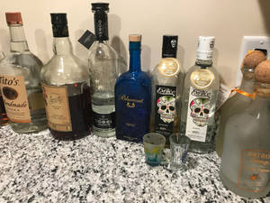 各種酒瓶和烈酒杯排列在花崗岩枱面上。