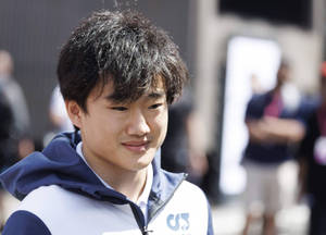 年輕男子穿著藍白連帽衫在戶外微笑。