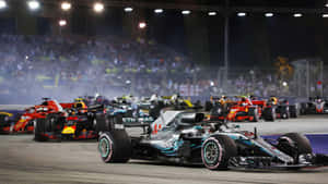 F1賽車在夜間賽道上奔馳，觀眾歡呼。 — 賽車 壁紙