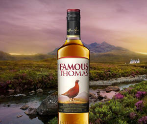 Famous Thomas威士忌酒瓶在蘇格蘭鄉村日落場景中，有山脈和紫色石楠花。