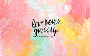 色彩繽紛的水彩背景上的love never gives up經文文字