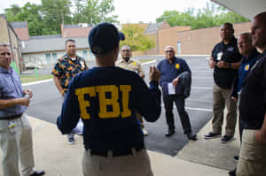FBI探員在停車場向一群男子簡報。