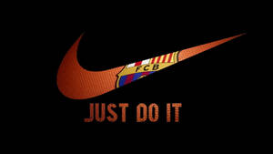 橙色 Nike 剔號、FC Barcelona 徽章及 Just Do It 標語在黑色背景上。