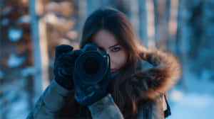 穿冬季外套的女性在雪地森林中手持相機