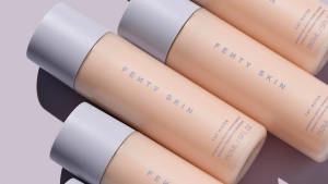 蜜桃色調的 Fenty Skin 粉底液瓶，薰衣草背景。