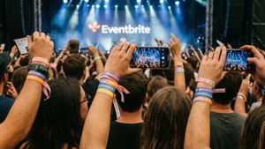 Eventbrite 活動的觀眾舉起手機錄製舞台表演。