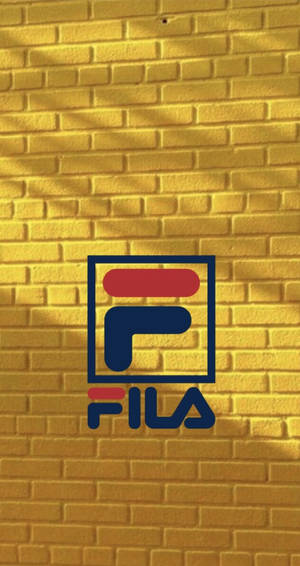 Fila 標誌在黃磚牆上帶有陽光陰影